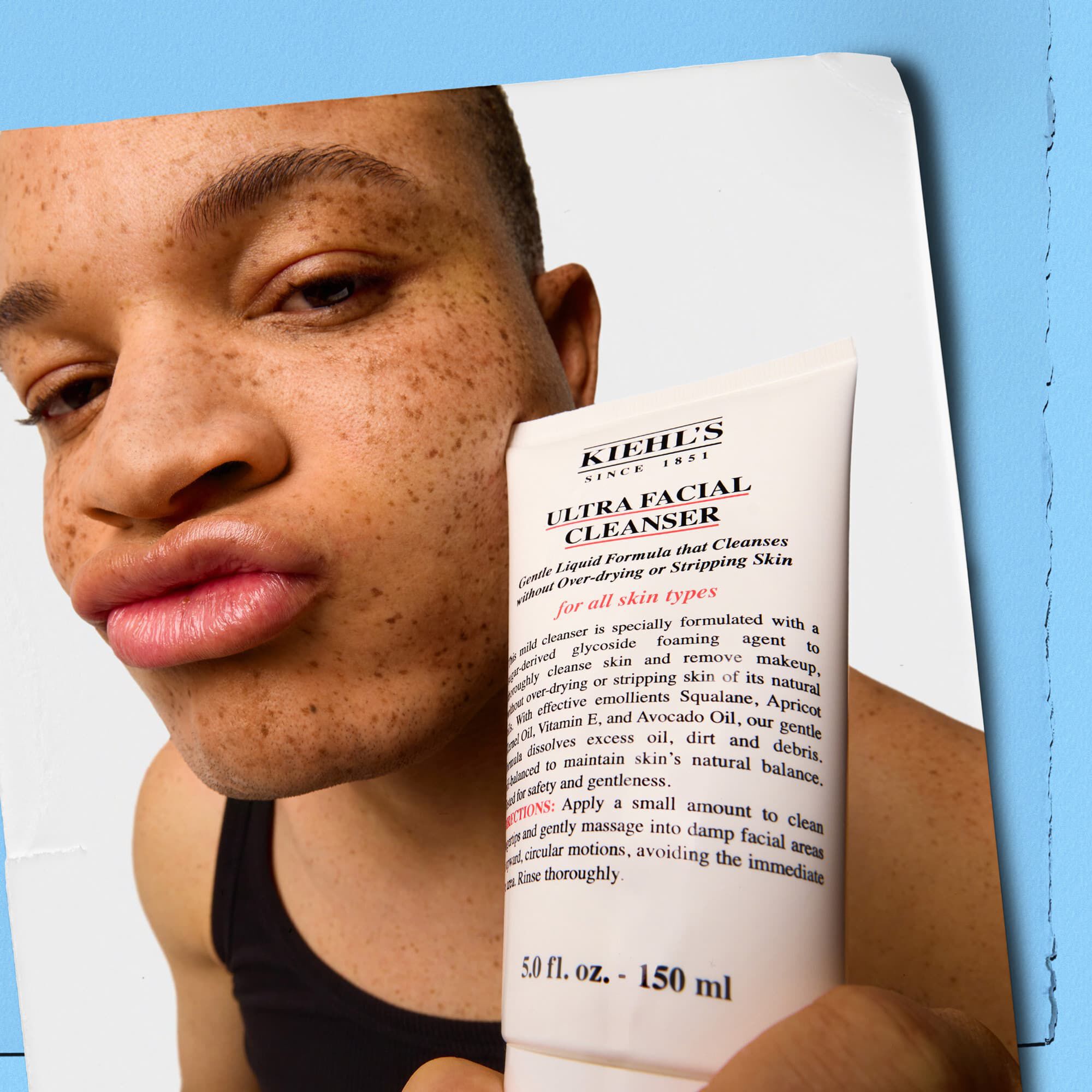 Modell, aki egy tubus Kiehl's Ultra Facial Cleansert tart