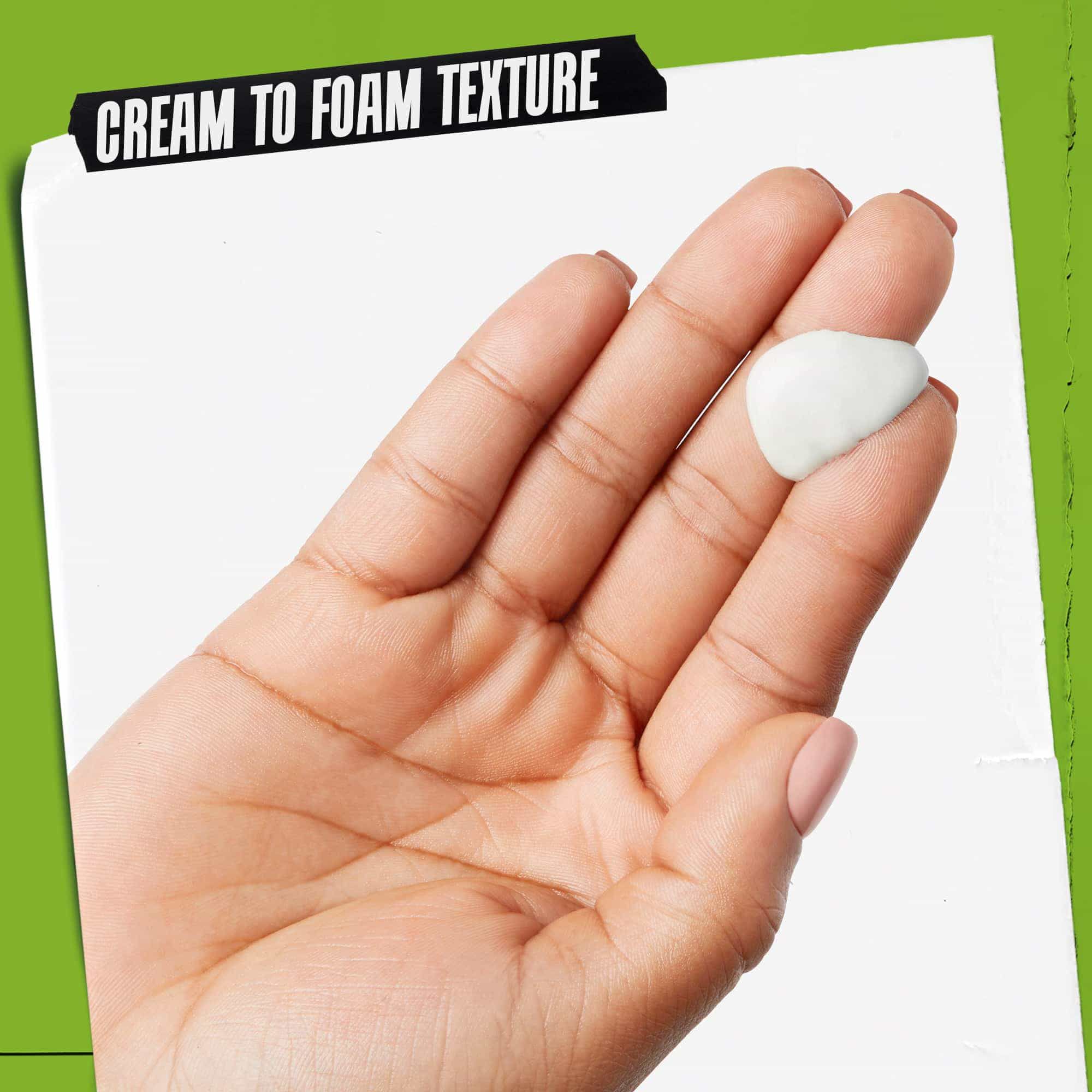 Egy kez Rare Earth Deep Pore Daily Cleanser-rel. A szoveg kiemeli: „Kremből habba alakulo textura”.