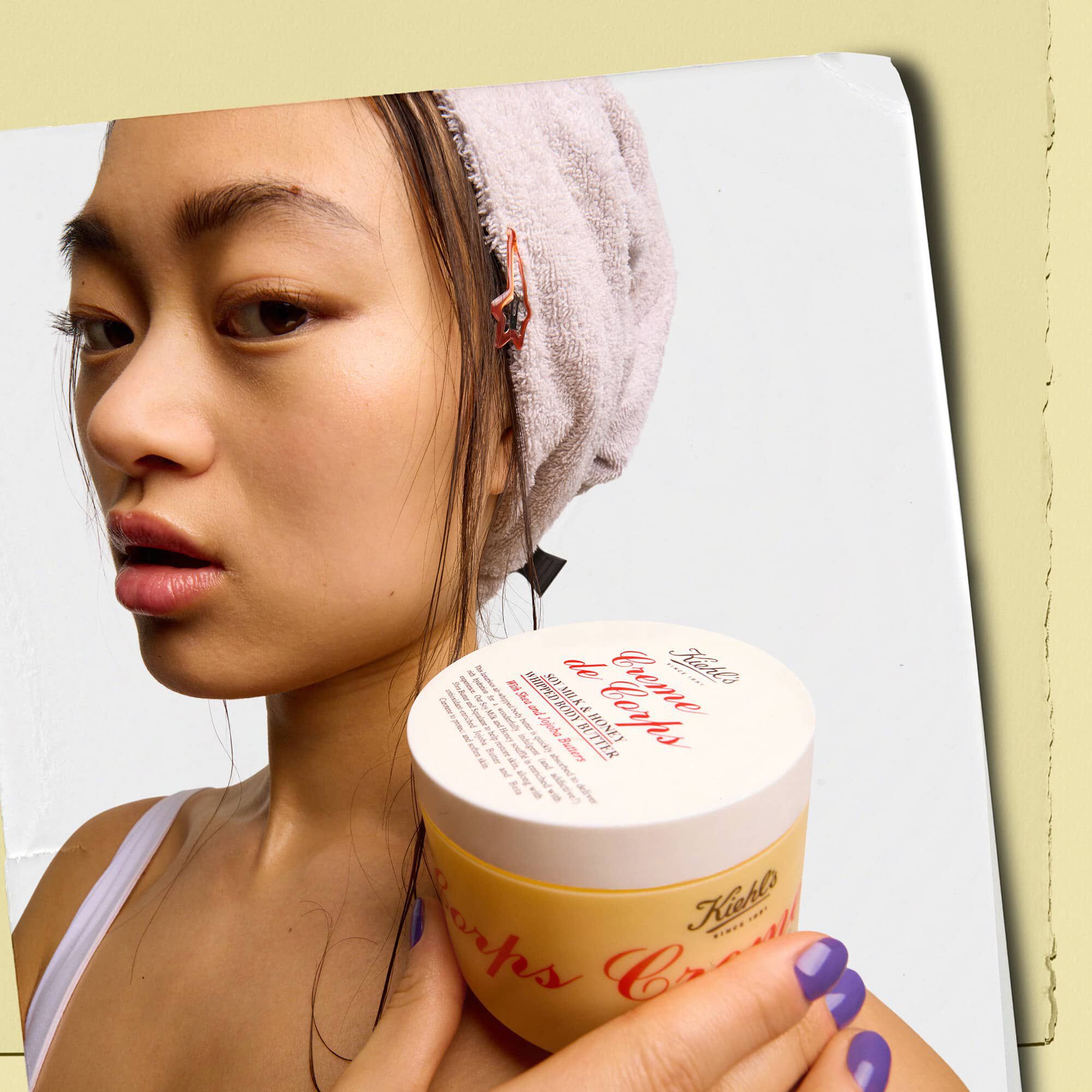 Modell, aki egy Kiehl's Creme de Corps Whipped Butter testvaj tegelyt tart