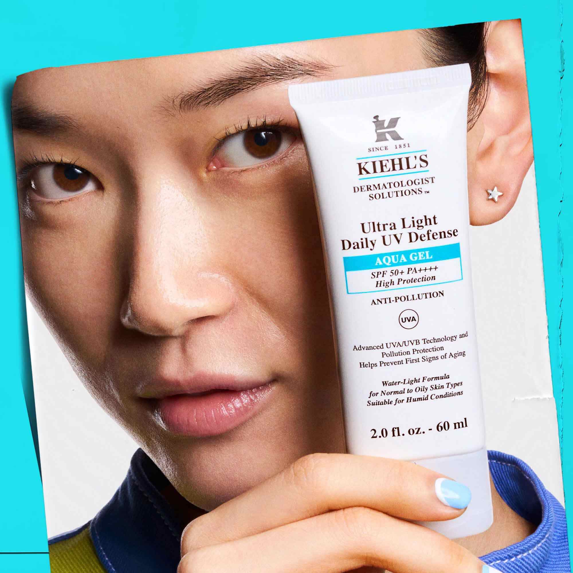 Egy modell Ultra Light Daily UV Defense Aqua Gel tubust tart a kezeben, bemutatva hordozhatosagat es konnyu hasznalatat.