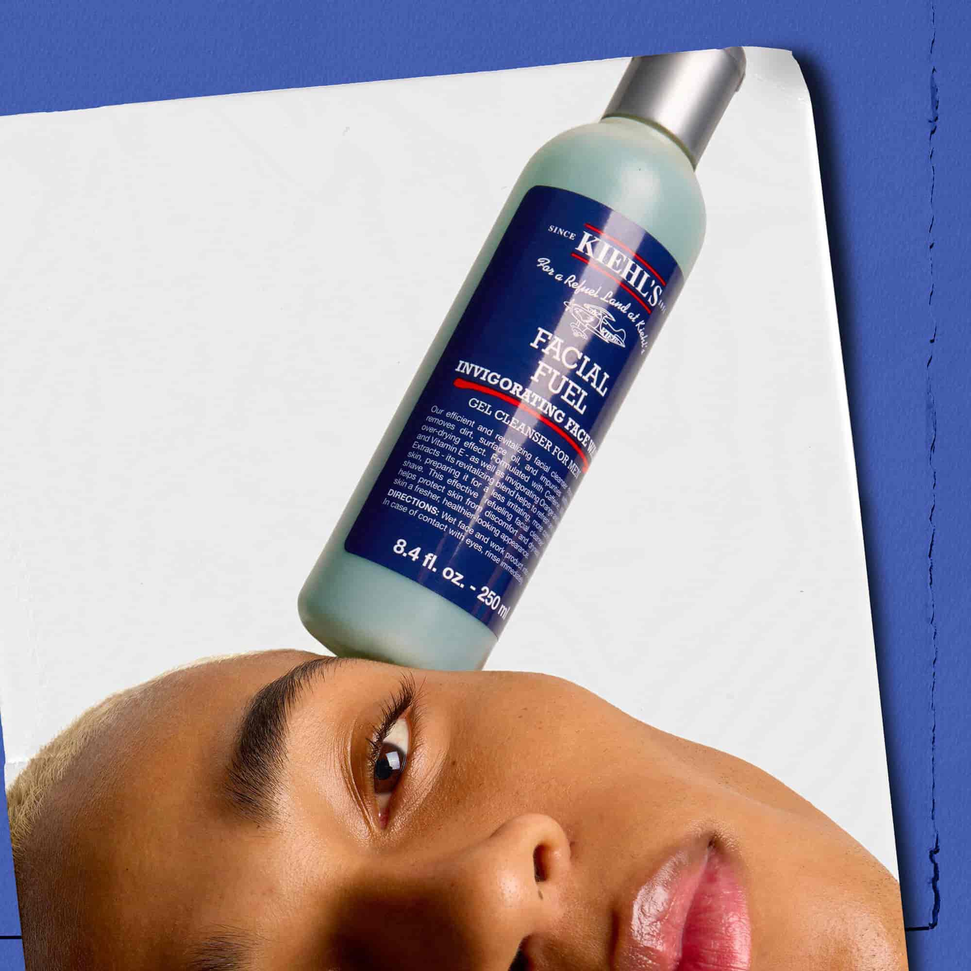 Modell, aki egy flakon Kiehl's Facial Fuel Energizing Face Wash arctisztitot egyensulyoz az arcan