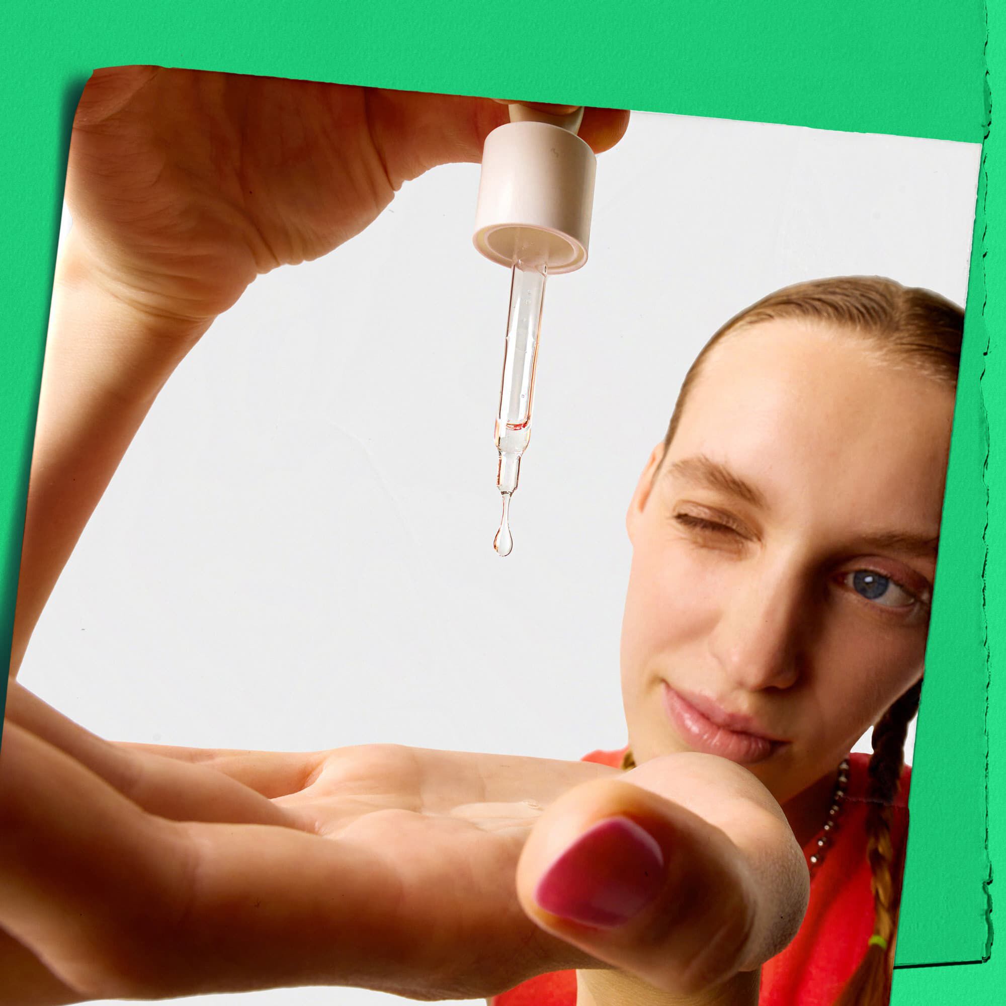 Modell, amint Kiehl's Ultra Pure High-Potency Serumot cseppent a kezere