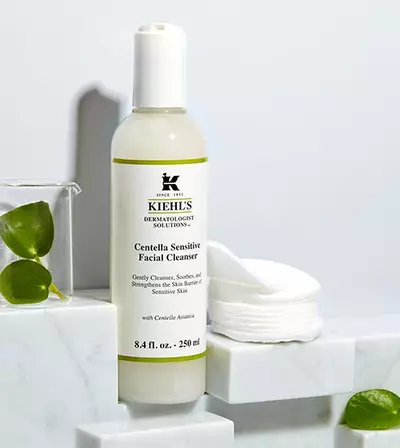 Kiehls Centella Sensitive arctisztito flakonja feher hatter előtt, pamut korongokkal es marvany feluleten.
