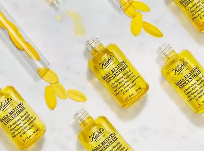 Kiehl's napi revitalizalo koncentratumok sarga uvegekben, viragokkal diszitve, marvany hatterrel.