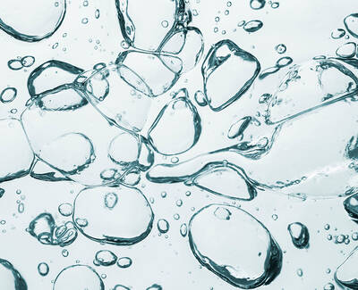 Close-up of transparent bubbles floating in a clear liquid, creating a sense of movement and depth.
